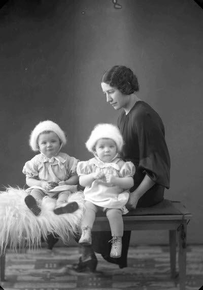 Porträtt av en dam och två barn. Ateljefoto.