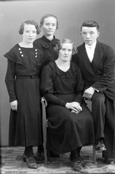 Porträtt av en herre och tre damer. Ateljefoto.