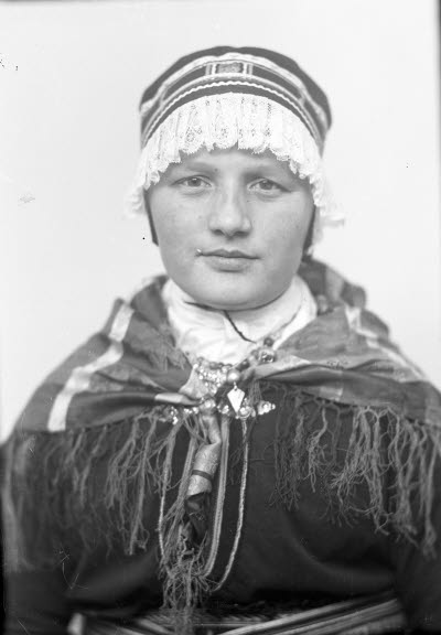 Porträtt av en dam i samedräkt. Ateljefoto.