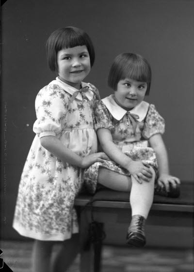 Porträtt av två barn, flickor. Ateljefoto.