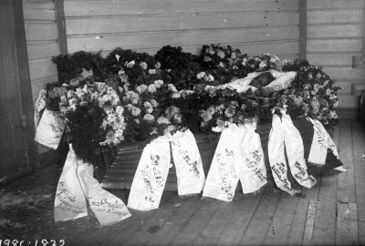 Kapellet; öppen kista. Oidentifierad. Kransar och blommor.