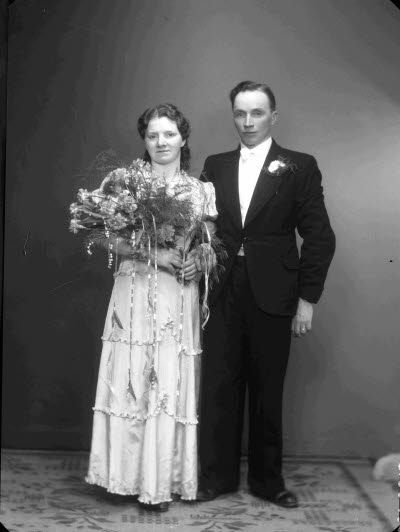 Porträtt av ett brudpar; en herre och en dam. Ateljefoto.