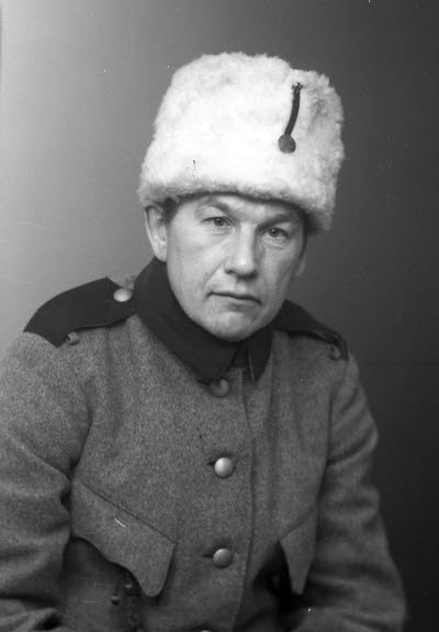 Porträtt av en herre i uniform och pälsmössa. Ateljefoto.