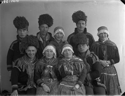 Porträtt av nio personer i samedräkter, gruppfoto.