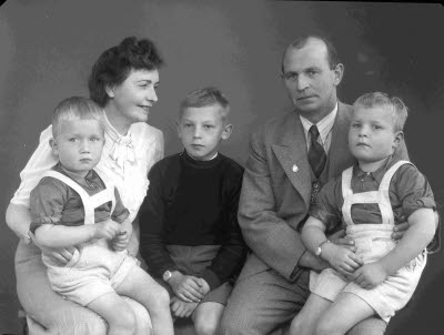 Porträtt av en herre och en dam med tre barn, pojkar. Ateljefoto.
