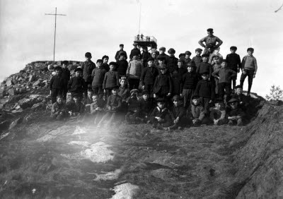 Skolklass på utflykt. Gruppbild; skolbarn och lärarinna. Oidentifierade.