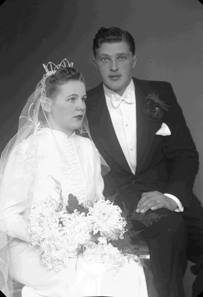 Porträtt av ett brudpar; en herre och en dam. Ateljefoto.