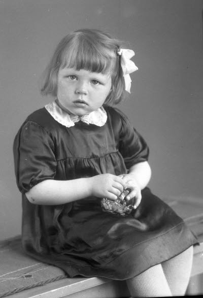 Porträtt av ett barn; en flicka. Ateljefoto.