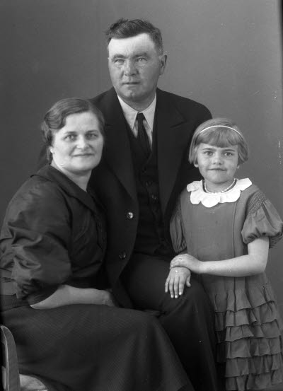 Porträtt av en herre, en dam och ett barn. Ateljefoto.