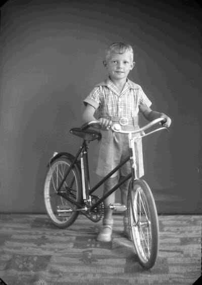 Porträtt av en pojke med en cykel. Ateljefoto.