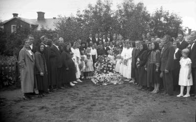 Herr Stålnackes begravning; blomsterdekorerad kista; begravningsgäster.