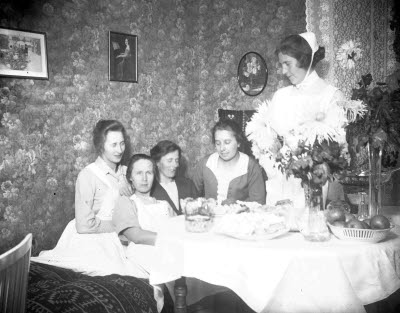 Interiör; gruppbild; fem damer (tre sjuksköterskor). Oidentifierade.