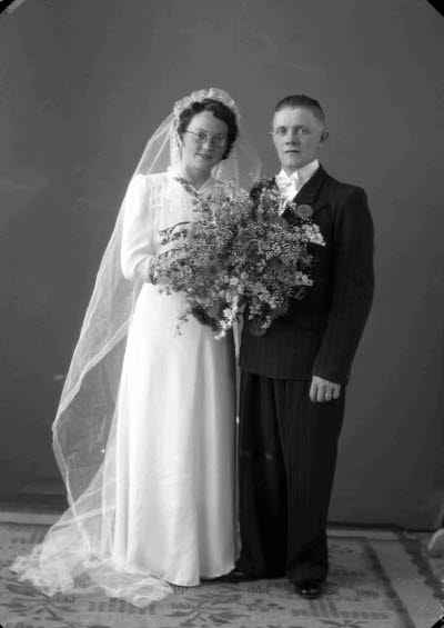 Porträtt av ett brudpar; en herre och en dam. Ateljefoto.