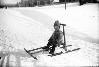 Ett barn på sparksläde.