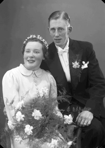 Porträtt av ett brudpar; en herre och en dam. Ateljefoto.