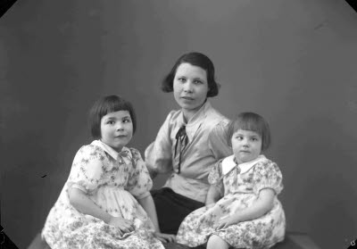 Porträtt av en dam och två barn, flickor. Ateljefoto.