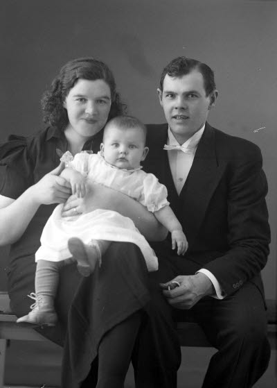 Porträtt av en herre och en dam med ett barn. Ateljefoto.