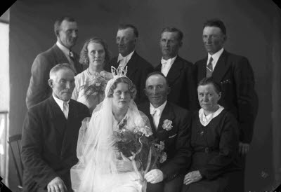 Porträtt av ett brudpar med familj. Ateljefoto.