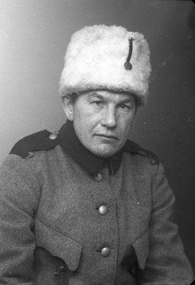 Porträtt av en herre i uniform och pälsmössa. Ateljefoto.