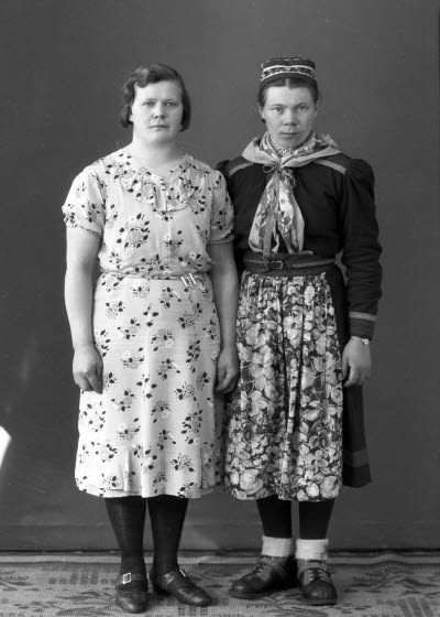 Porträtt av två damer, varav en i samedräkt. Ateljefoto.