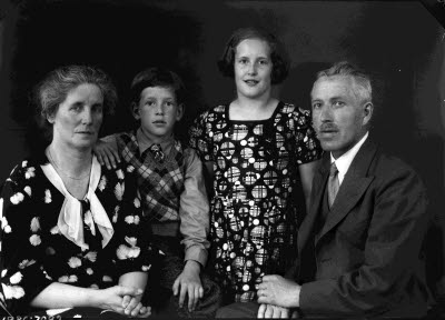 Porträtt av en herre, en dam och två barn; flicka och pojke. Ateljefoto.