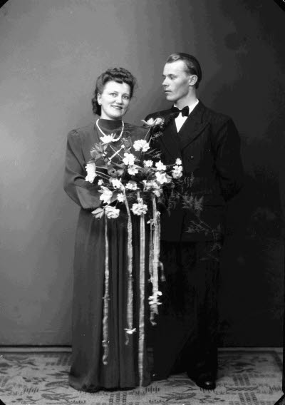 Porträtt av ett brudpar; en herre och en dam. Ateljefoto.