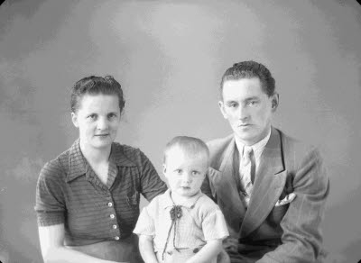 Porträtt av en herre och en dam med ett barn. Ateljefoto.