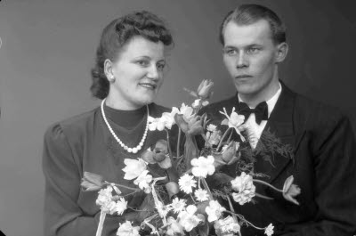 Porträtt av ett brudpar; en herre och en dam. Ateljefoto.