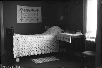 Fransk järnsäng med virkat överkast.