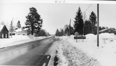 Vägskylt; ortnamnsmärke Junosuando. Småort; by. Landsväg, bebyggelse; hus.