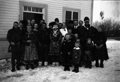 Gruppbild framför skolbyggnad. Samedräkter.