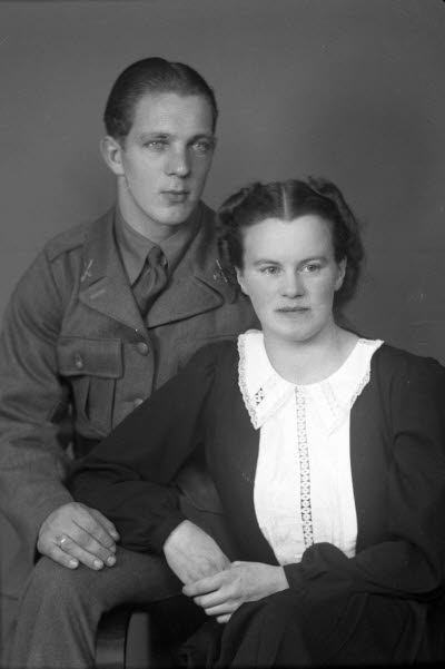 Porträtt av ett par; en herre i militäruniform och en dam. Ateljefoto.