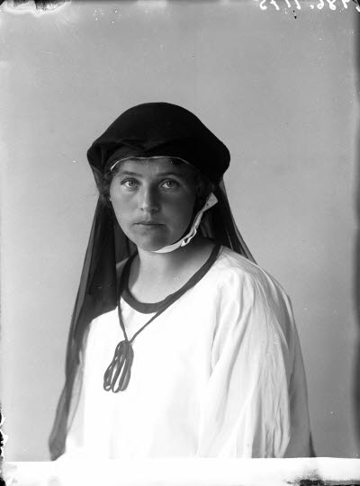 Porträtt av en ung dam i slöja. Ateljefoto.