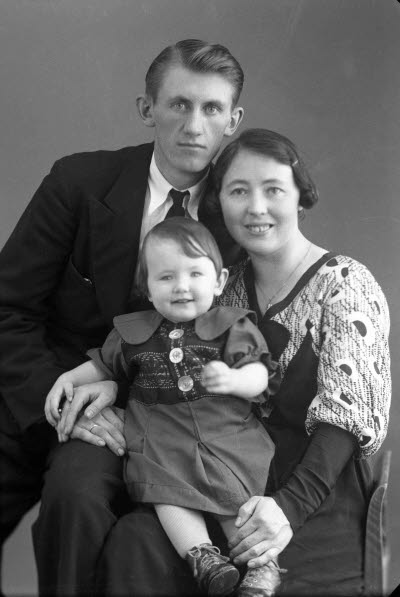 Porträtt av en herre och en dam med ett barn. Ateljefoto.