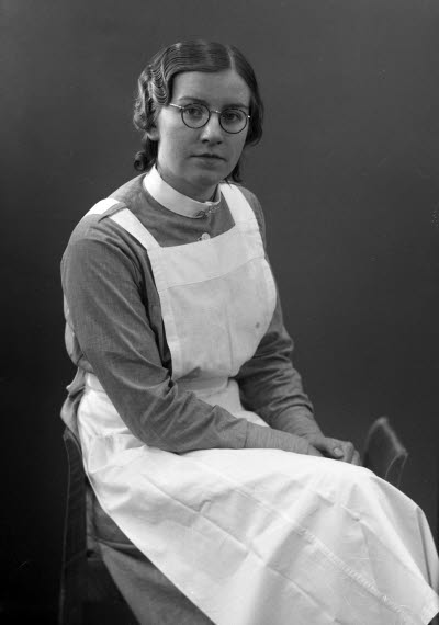 Porträtt av en dam i sköterskeuniform. Ateljefoto.