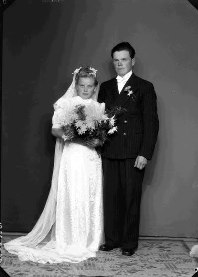 Porträtt av ett brudpar; en herre och en dam. Ateljefoto.