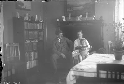 Ett par med ett barn. Hemmiljö; vardagsrum.