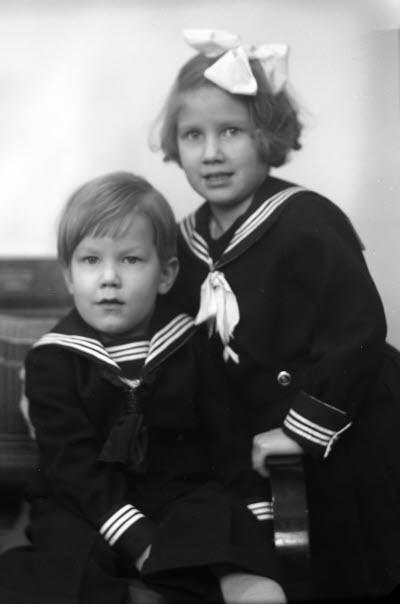 Porträtt av två barn; flicka och pojke. Ateljefoto.