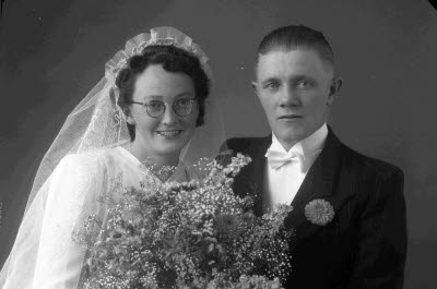 Porträtt av ett brudpar; en herre och en dam. Ateljefoto.