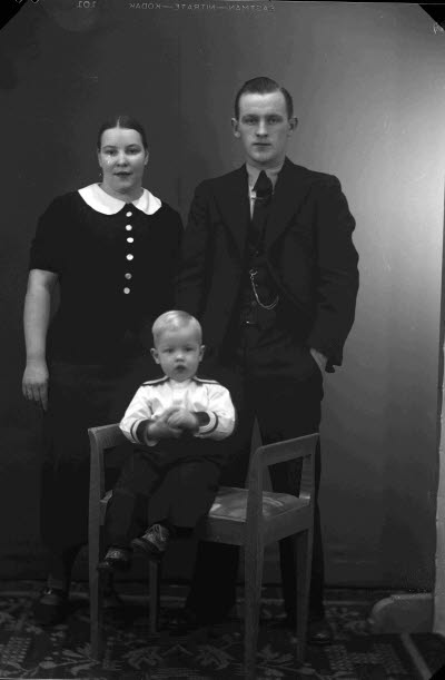 Porträtt av en dam och en herre med ett barn. Ateljefoto.