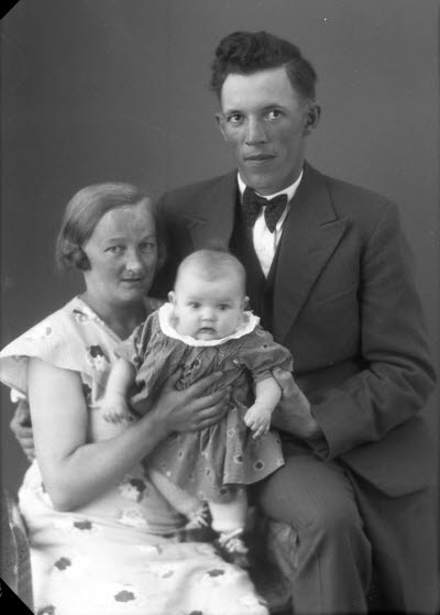 Porträtt av en herre och en dam med ett barn. Ateljefoto.