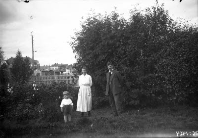 Ett par med ett barn. Trädgårdsmiljö, Gällivare.