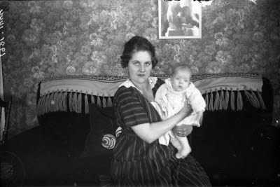 En kvinna och ett barn i hemmiljö. Vardagsrum.