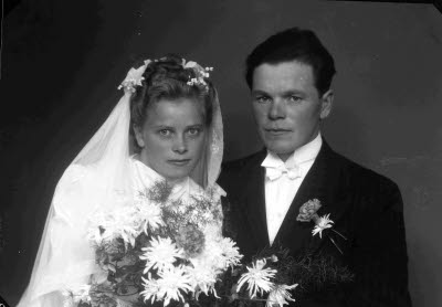 Porträtt av ett brudpar; en herre och en dam. Ateljefoto.