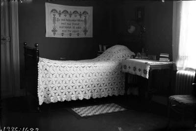 Fransk järnsäng med virkat överkast.