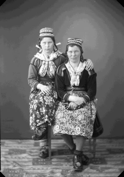 Porträtt av två damer i samedräkter. Ateljefoto.