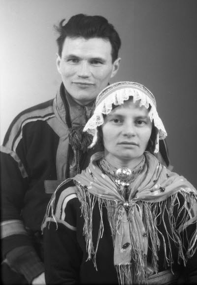 Porträtt av ett par i samedräkter; en herre och en dam. Ateljefoto.