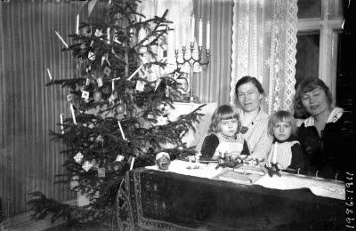 Fotograf Ida Barrel med systern Hilda Styrman och syskonbarnen. Vardagsrum, interiör. Julgran.