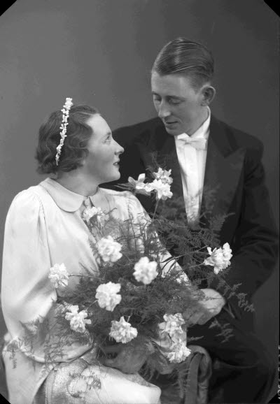 Porträtt av ett brudpar; en herre och en dam. Ateljefoto.