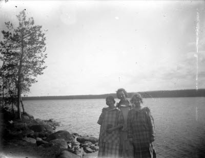 Tre damer vid älv eller sjö, ev. Vassaraträsk? Oidentifierade.